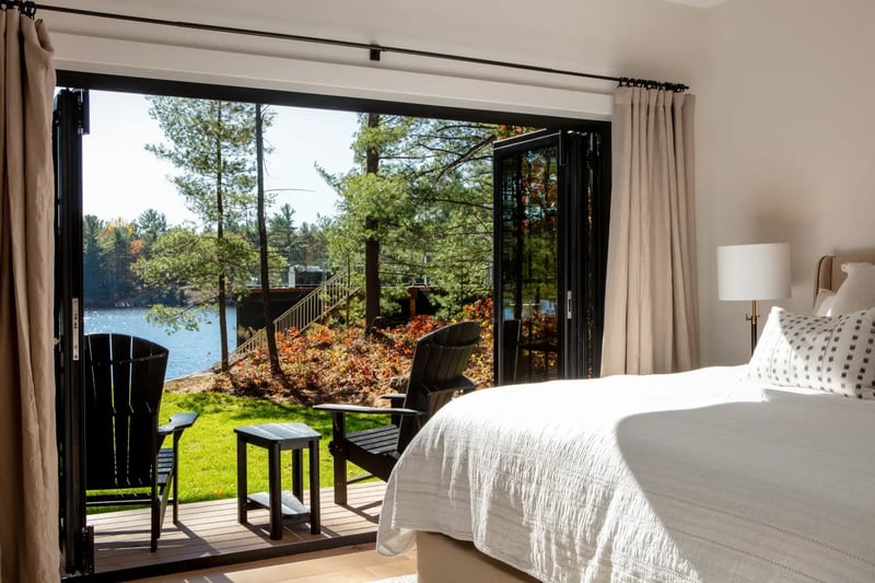 Traditional-Lakeside-Cottage-Lakeside-Escape-Project-Portfolio-Interior-Primary-Bedroom-Folding-Doors-Private-Deck-Normerica-Timber-Homes